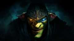 A close-up of Styx looking up from under his hood in darkness, one eye glowing amber, and the other light blue