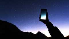 Best stargazing apps: Image shows person holding mobile up to starry night sky
