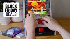 Black Friday deals GamesRadar+ badge at top left next to Evercade Alpha arcade machine with hands using controls to play Street Fighter Alpha.