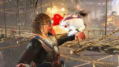A pudgy cat stands on the player's arm in Nioh 3 and emits a warm glow, with a rickety wooden bridge in the background, cropped