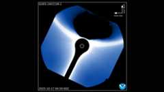 A black shadow is seen at the top right of the image with a blue halo of light in the middle where the coronagraph is