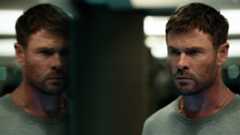Chris Hemsworth's Davis looking out of a window at his own reflection in Crime 101