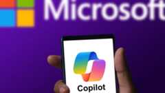 Microsoft Copilot app running on a phone with Microsoft logo in background