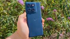 The Motorola Edge 60 in front of a flowery bush.