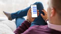 Person checking their phone with iMessage chat bubbles on their phone screen.