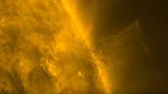 Close-up video of the Sun, filling the left half of the view, its surface covered what looks like moving, glowing hairs accompanied by some short-lived bright arcs. Protruding to the right, in the centre of the video, is dark material that looks almost feathery, with thin streaks flowing both away from and towards the Sun.