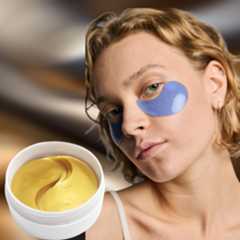 a woman with short blonde hair wearing a blue under eye mask next to a white jar with gold under eye masks