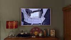 The Samsung Frame TV above a wooden book case.