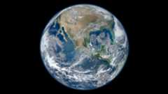 Earth covered with swirling white cloud and deep blue oceans.