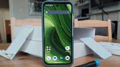 The Fairphone 6 standing before various boxes.