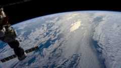 the view of blue waters and white clouds on Earth from a space station high above the planet