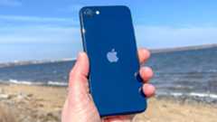 iPhone SE 2022 in hand at beach Midnight color