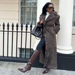 @nlmarilyn wearing a brown fur coat, black leggings and brown knee-high boots