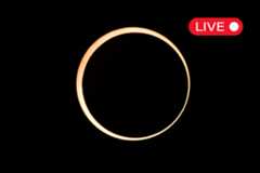 a ring of fire annular solar eclipse appearing as a golden yellow ring of light against a black background. in the top right corner there is a little graphic with "live" written in white text on a red background. 