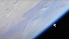 The SpaceX Dragon CRS-26 cargo ship seen in space with the blue Earth below.