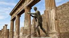 statue of Apollo in front of ruins of a temple at Pompeii