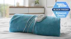 Heated blanket on a bed in airy room and Black Friday deal badge top right corner