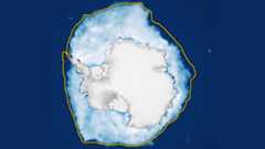 A white blob of ice surrounded by a yellow outline sits in a navy blue ocean