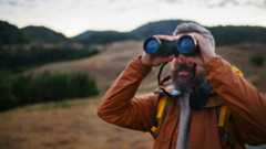 Man using binoculars in the hills