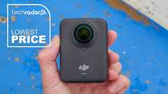 DJI Osmo 360 camera in the hand, while bright blue painted wall backdrop and lowest price text overlay