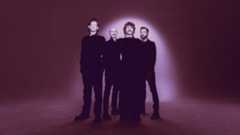 AFI looking solemn against a spotlit purple background