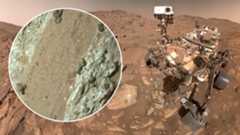 A mars rover with an inset showing a close up of mars rocks
