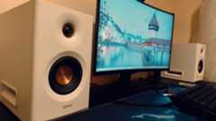 White Edifier MR5 speakers on a black desk