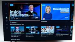 The home screen on Sling TV shows cable news options on a wall-mounted TV