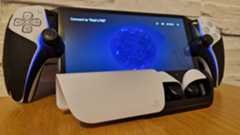 PlayStation Pulse Explore earbuds on a wooden surface with a white brick background