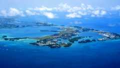 Bermuda archipelago: aerial view of Bermuda, the most significant islands are connected by bridges and appear to form one landmass - blue waters of the Atlantic Ocean and from the right the islands of St George, Higgs and Horseshoe, Hen, Peggy, Whalers, Governor, Paget, Smith, Brooks, Oswego, St. David (airport), Nonsuch, Coney, Bermuda, Ireland, Somerset. 