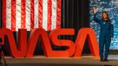 people in blue jumpsuits smile and wave.