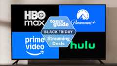 A TV on a stand displaying logos for HBO Max, Paramount Plus, Prime Video and Hulu around a Tom&#039;s Guide Black Friday streaming deals badge