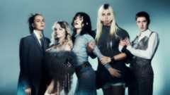 The Last Dinner Party staring at the camera against a blue background