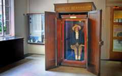 The auto icon of philosopher Jeremy Bentham at University College London (UCL). Notice how none of his preserved skin is visible, and that the head atop his shoulders is a wax replica.
