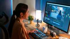 Woman sitting at video editing screen