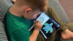 Boy using Apple Pencil to draw on iPad 2022