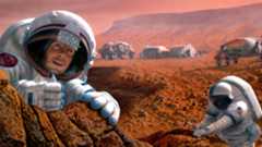 Two astronauts wearing white spacesuits dig around in the dirt near a series of gray buildings on the reddish dusty surface of the planet Mars