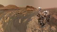 a rover on the surface of mars with a bunch of rocks and mountains surrounding