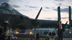 President Donald Trump stands beside an F-35 in Japan
