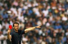 A football referee holding up a red card.