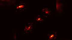 Five bright red lights glow in a cross formation in the darkness of space