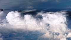 photo of fluffy white clouds clumping together in a bright blue sky