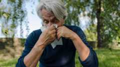 Close up on older man blowing his nose