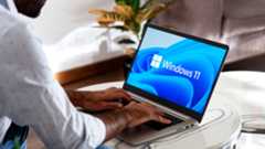 A man typing on a Windows 11 laptop