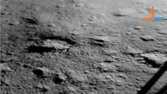 the gray surface of the moon can be seen beside the leg of a lunar lander