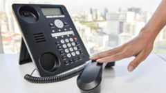 Business phone put on hold by hand