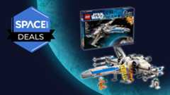 A white and blue spaceship is displayed on a blue planet background with a dark blue product box and orange minifigures and a robot surrounding it.