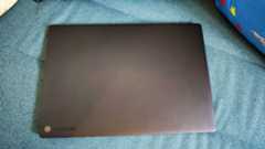 A black ASUS ProArt P16 laptop on a green sofa