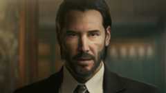 John Wick stares into the camera while wearing a suit