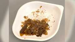 white plastic plate with brownish flakes on it